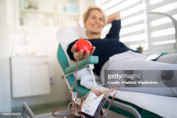 mujer feliz se acuesta mientras dona su sangre - banco de sangre fotografías e imágenes de stock