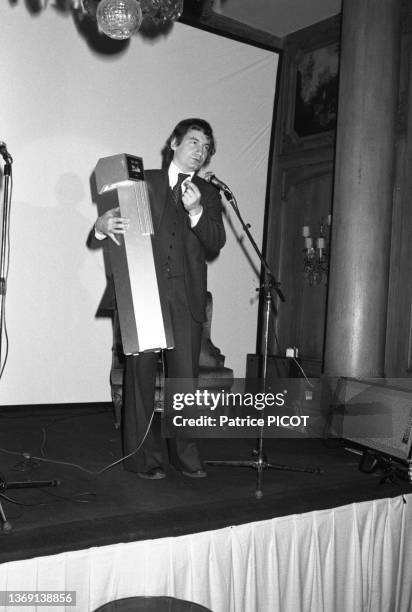 Pierre Desproges sur scène lors du lancement du nouveau briquet de la maison Céline à Paris le 23 mars 1977