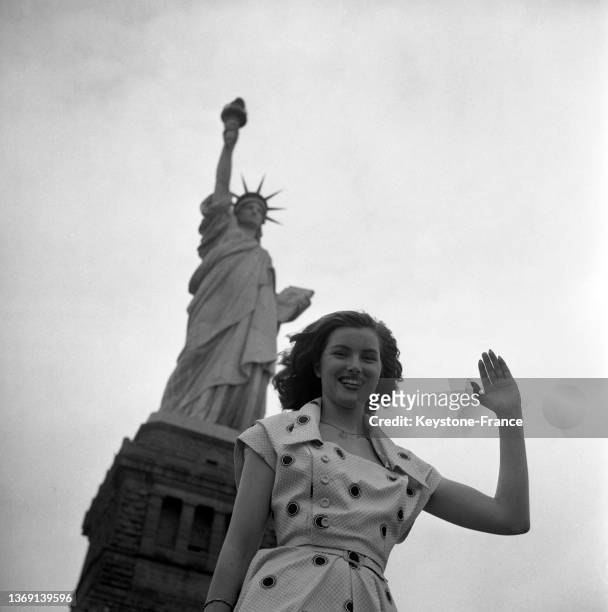 Christiane Martel posant devant la statue de la Liberté à New York avant le concours de Miss Univers, le 9 juillet 1953.
