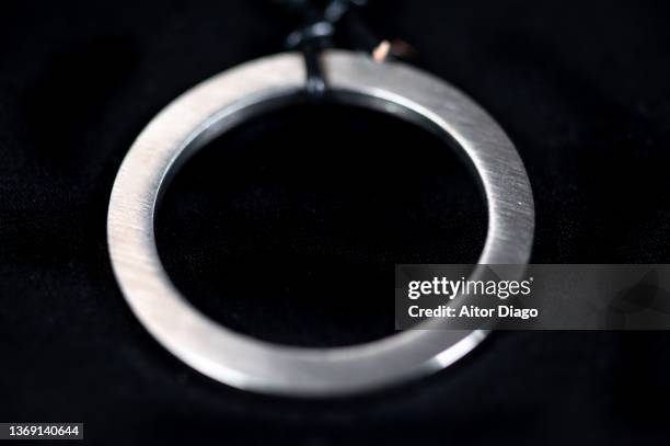 detail of a circular metal pendant. black background. - white gold stock pictures, royalty-free photos & images