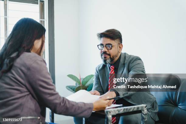 an asian real estate agent dealing with a client. - real estate office stockfoto's en -beelden