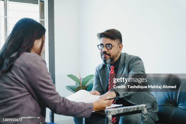 an asian real estate agent dealing with a client. - grounds worker stock pictures, royalty-free photos & images