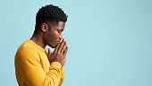 Side view of praying african american young man, copy space