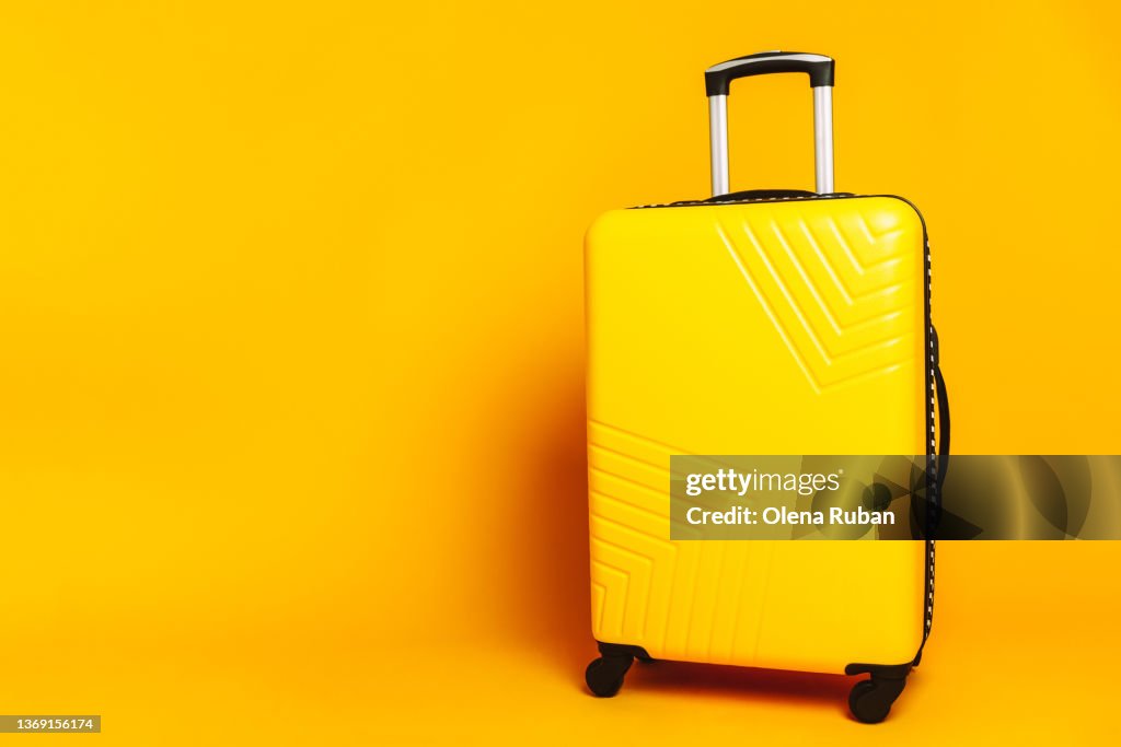 Suitcase against yellow background.
