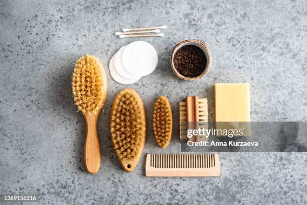 close-up of wooden dry skin body brushes, bamboo tooth brushes, hair brushes, nail brush, cotton swabs and pads, cup of coffee scrub and soap  on concrete background, top view. spa at home, flat lay. zero waste concept. - dry hair photos et images de collection