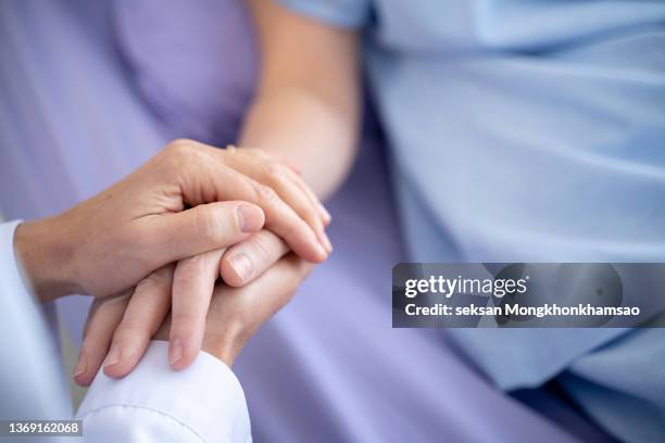 friendly female doctor shaking hands with patients - cuidados paliativos fotografías e imágenes de stock