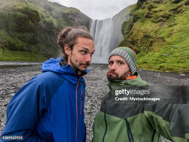 two friends take selfie on near waterfall in iceland - 2 dramatic landscape stock pictures, royalty-free photos & images