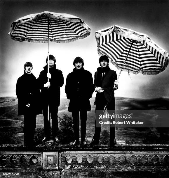 The Beatles pose for a group portrait, holding striped umbrellas, at a hotel in Perthshire, Scotland, 1964. Left to right: Ringo Starr, John Lennon ,...