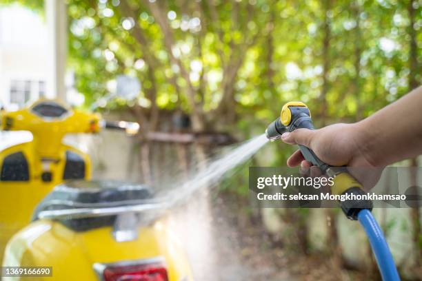 washing his motorcycle or scooter - motorbike wash stock pictures, royalty-free photos & images