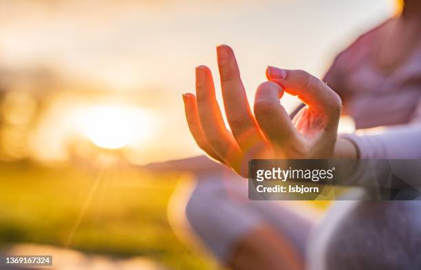 close-up of woman meditating in nature - meditating stockfoto's en -beelden