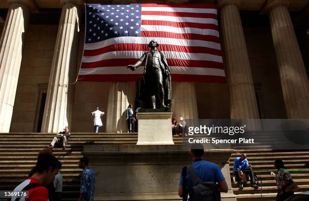 Pedestrians walk around the George Washington statue in front of Federal Hall September 5, 2002 in New York City. Congress will return to its 18th...