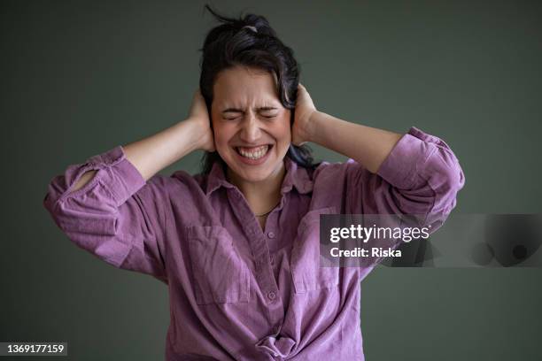 portrait of a woman covering her ears with hands - hand to ear stock pictures, royalty-free photos & images