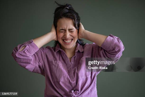 portrait of a woman covering her ears with hands - not listening stock pictures, royalty-free photos & images