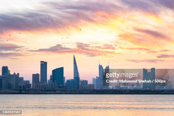 the beauty of bahrain,view of buildings in city against cloudy sky,bahrain - bahrain stock pictures, royalty-free photos & images
