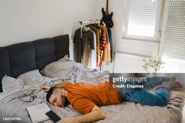 young male student falls asleep while reading the book - sleep study stock pictures, royalty-free photos & images