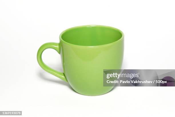 green teacup isolated in white,close-up of green cup over white background - マグカップ ストックフォトと画像