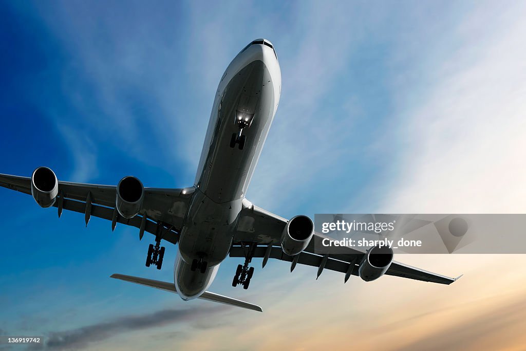 Jet airplane landing at sunset