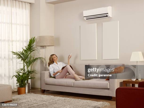 resting in a room with air conditioner - new woman magazine stock pictures, royalty-free photos & images