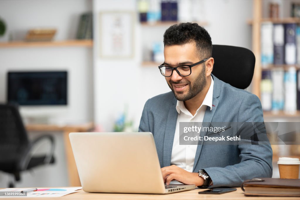 Porträt eines gutaussehenden jungen Geschäftsmannes, der im Büro arbeitet
