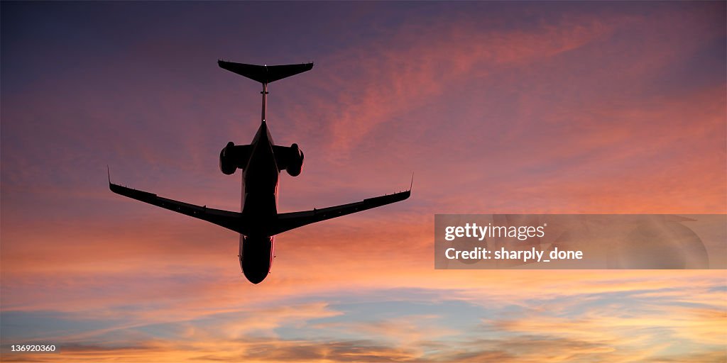 Avion privé d'entreprise avion volant au coucher du soleil