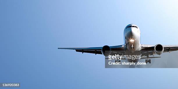 jet airplane landing in blue sky - landing touching down stock pictures, royalty-free photos & images
