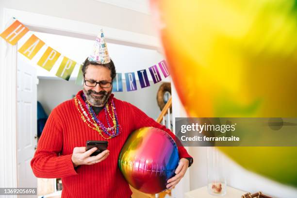 man decorating for a birthday party gets distracted on the phone - garland bildbanksfoton och bilder