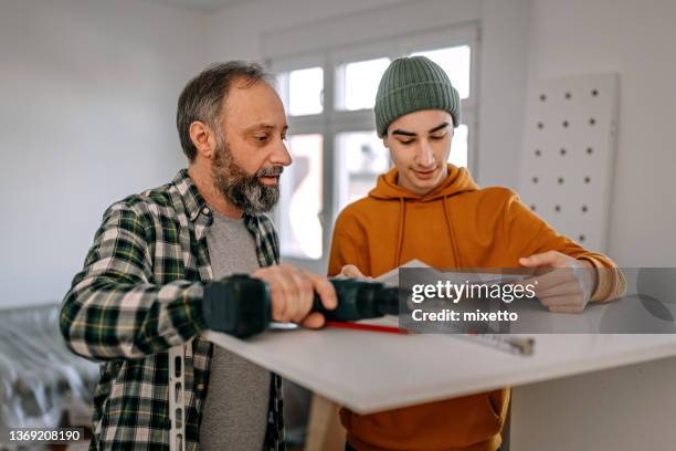 son assisting father in building diy shelf and rack - building shelves stock pictures, royalty-free photos & images