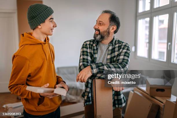 boy and father talking while renovating apartment - parent and young adult stock pictures, royalty-free photos & images