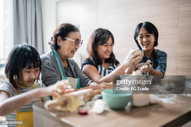 happy family making mess while preparing a cake at home - learning generation parent child stock pictures, royalty-free photos & images