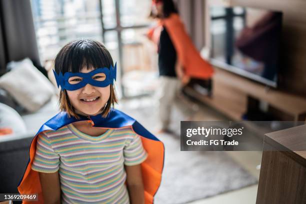 portrait of a girl dressed as a superhero at home - royalty free space images stockfoto's en -beelden