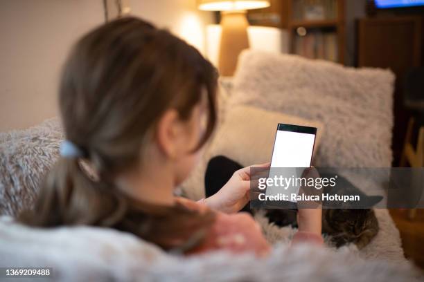 girl using mobile phone indoor - animal call fotografías e imágenes de stock