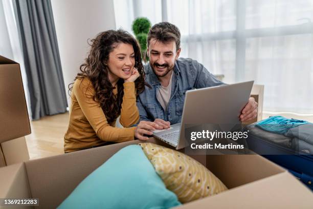 husband and wife having fun unboxing packages and moving into their new home - new boyfriend stock pictures, royalty-free photos & images
