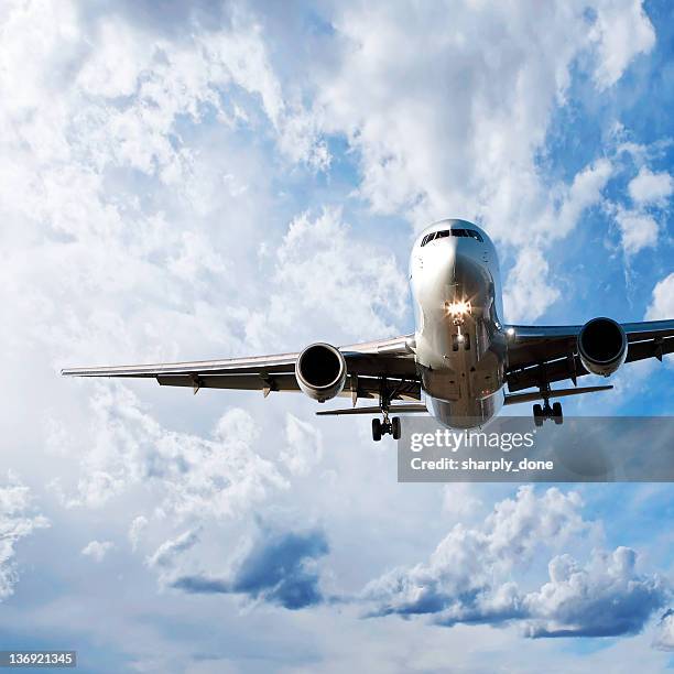jet airplane landing in bright sky - air cargo airplane stock pictures, royalty-free photos & images