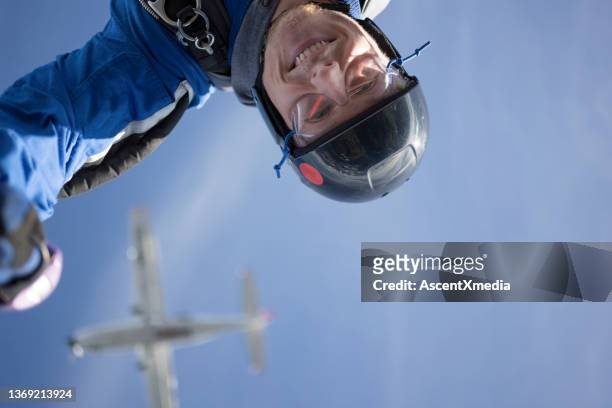 skydiver falls through clear skies, aerial flight - aerial stunts flying stock pictures, royalty-free photos & images