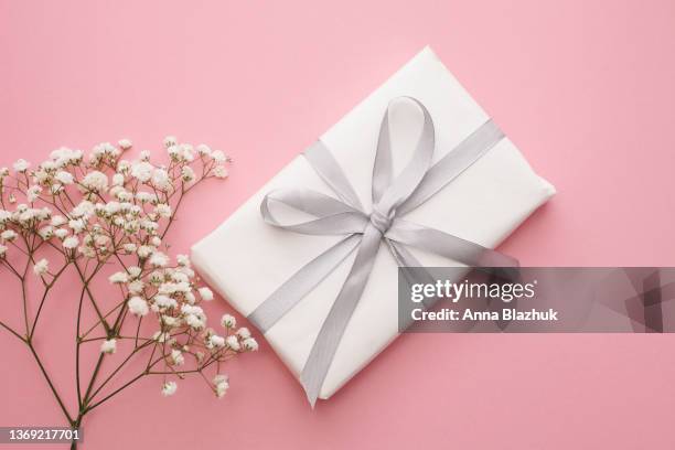 gypsophila white flowers over pastel pink background and white gift box, spring floral greeting card. - white flower paper stock pictures, royalty-free photos & images