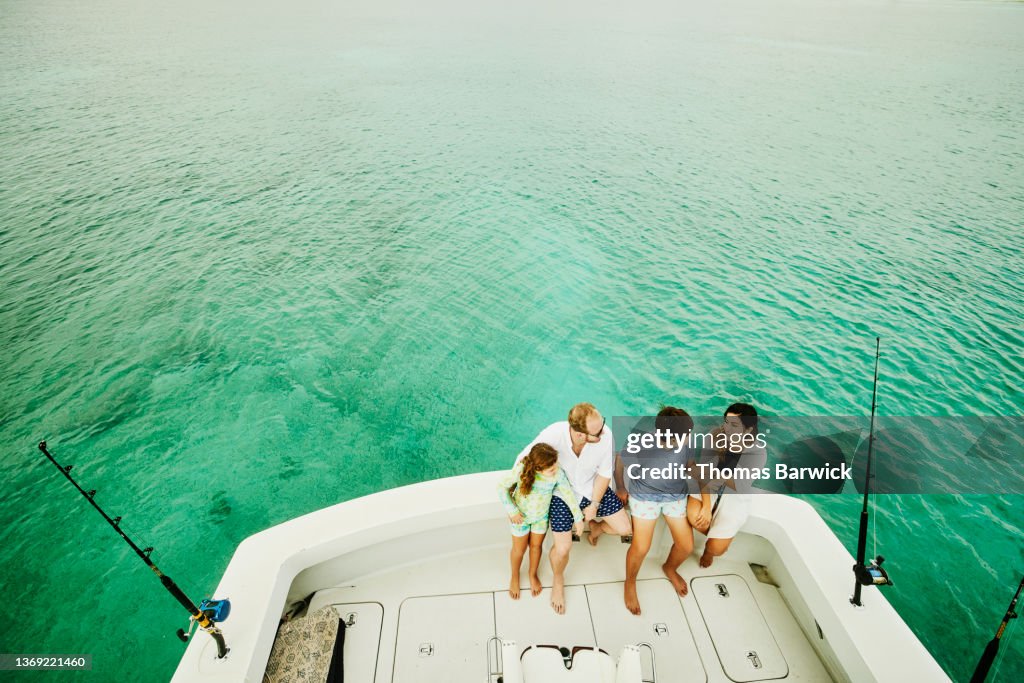 Wide shot high angle view of family on stern of sport fishing boat while on vacation
