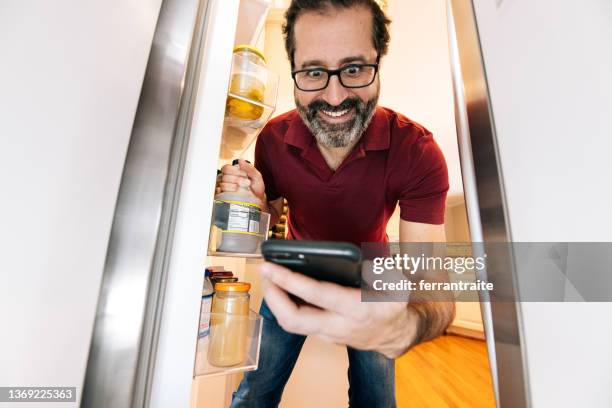 l'uomo ottiene gli ingredienti dal frigorifero - funny fridge foto e immagini stock