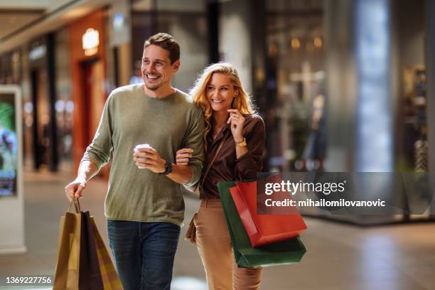 riéndose de su camino a través del centro comercial - bolsa de papel fotografías e imágenes de stock