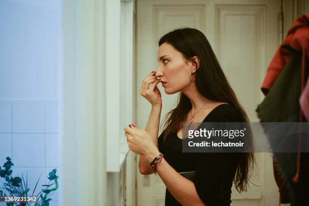 young woman putting make up in her apartment - eyeliner stock pictures, royalty-free photos & images