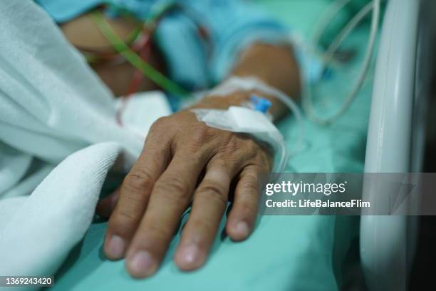 patient's hand with saline intravenous. - iv going into an arm 個照片及圖片檔