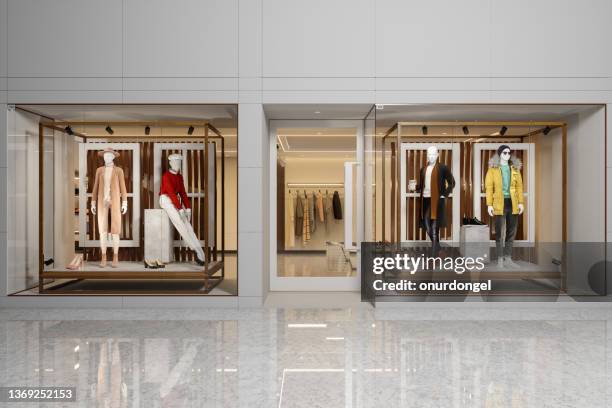 exterior of clothing store with women's and men's clothing on mannequins displaying in showcase. - fashion shopping stockfoto's en -beelden
