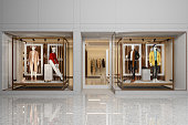 Exterior Of Clothing Store With Women's And Men's Clothing On Mannequins Displaying In Showcase.
