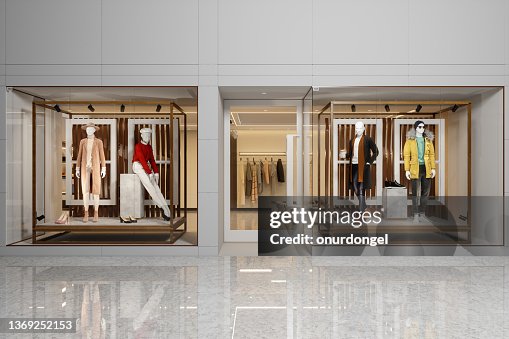 Exterior Of Clothing Store With Women's And Men's Clothing On Mannequins Displaying In Showcase. Exterior Of Clothing Store With Women's And Men's Clothing On Mannequins Displaying In Showcase.