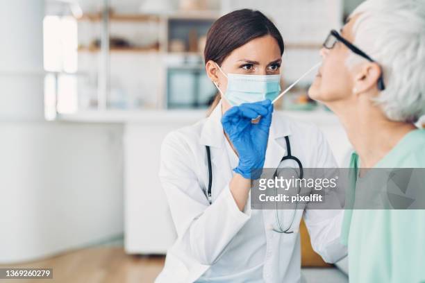 nasal covid-19 test on a senior patient - nose mask stock pictures, royalty-free photos & images