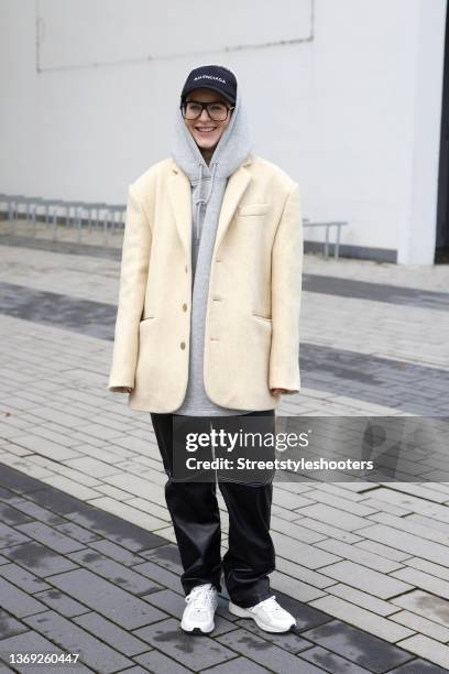 Influencer Maria Barteczko is seen wearing black logo baseball cap by Balenciaga, a yellow oversized wool blazer by Marcela London, a grey oversized...