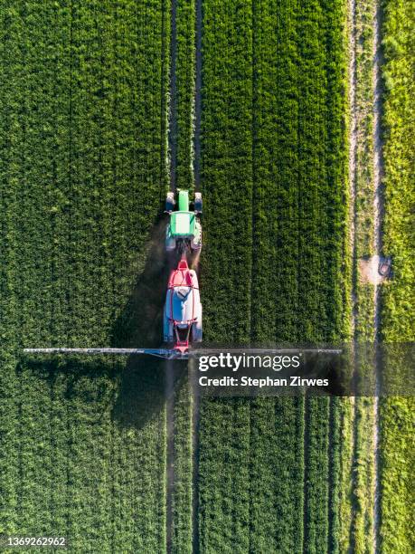 aerial view tractor spraying lush green field, baden-wuerttemberg, germany - landwirtschaft deutschland stock-fotos und bilder