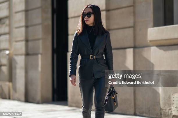 May Berthelot wears black sunglasses, gold and pearls pendant Edward earrings from Leo Sedim, a black turtleneck pullover, a gold with white pendant...