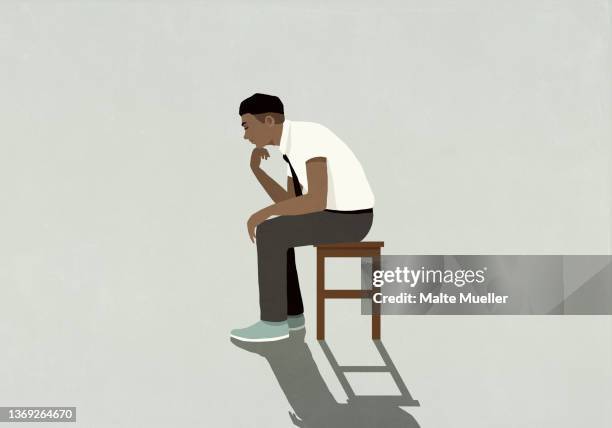 thoughtful young businessman sitting with hand on chin - mann grauer hintergrund stock-grafiken, -clipart, -cartoons und -symbole