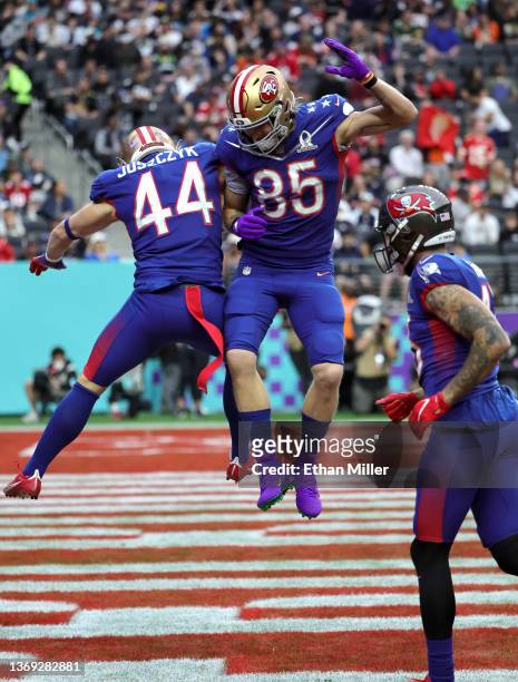 Kyle Juszczyk of the San Francisco 49ers and NFC celebrates with 49ers teammate George Kittle and Mike Evans of the Tampa Bay Buccaneers after...