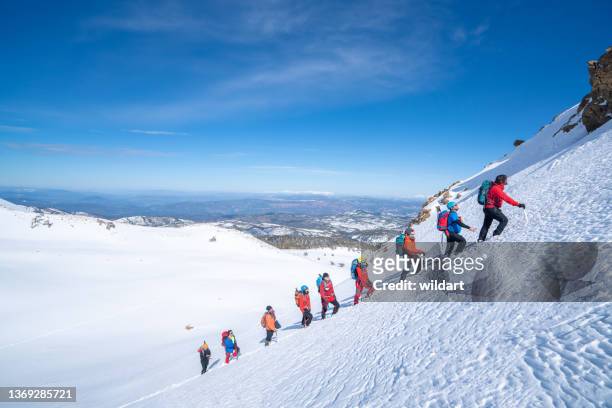 mountain alpine climbing team is walking in a row in high altitude mountain peak in winter - people climbing walking mountain group stockfoto's en -beelden